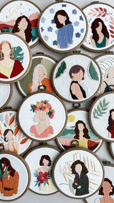 embroidered portraits of women are displayed on wooden hoops