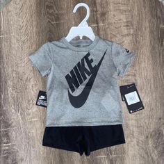 Nike Baby 2 Piece Outfit Size 12 Months Includes: Gray Nike T-Shirt Black Nike Shorts Shirt: 100% Polyester Shorts: 100% Polyester Brand New With Tags Retails For $32.00 May Bundle I Will Remove Hanger For Less Shipping Cost Unless Asked Otherwise :) If You Have Any Questions, Feel Free To Message Me :) Check Out My Page For More I Have A Ton Of Baby Items And Clothes On My Page- New And In Good Condition Gray Sporty Tops For Playwear, Gray Short Sleeve Letter Print Sets, Baby Nike Outfits, Nike Baby Clothes, Reborn Clothes, Outfit Size 12, Black Nike Shorts, Baby Nike, Gray Nike