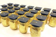 graduation caps are lined up in rows on top of gold glittered jars with black caps