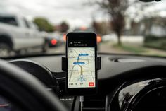 a cell phone sitting on top of a car dashboard next to a steering wheel and dash