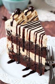 a piece of cake with chocolate and peanut butter frosting on a plate next to a fork