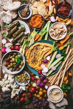 an assortment of vegetables and dips laid out on a table