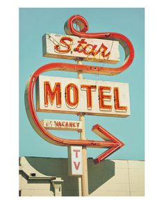 an old motel sign with two arrows pointing in different directions