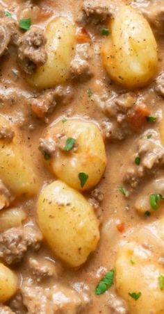 potatoes and meat stew in a bowl with garnishes on top, ready to be eaten