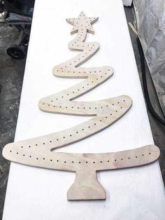 a white table topped with wooden christmas tree cut out of plywood and pegs