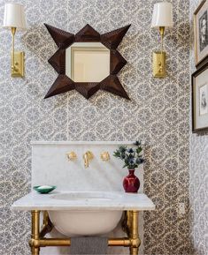 a white sink sitting under a bathroom mirror next to a wall mounted faucet