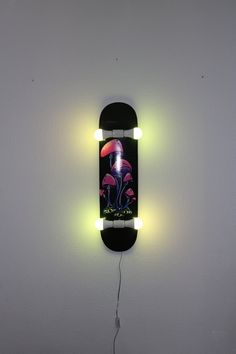 a skateboard mounted to the side of a wall with neon lights on it's sides