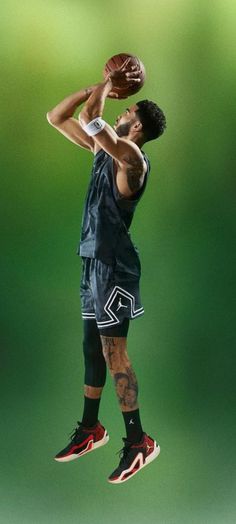 a basketball player jumping up into the air with a ball in his hand while wearing black shorts