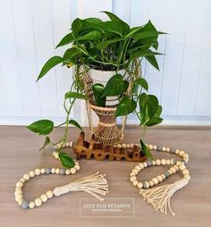 a potted plant sitting on top of a wooden table next to beads and tassels