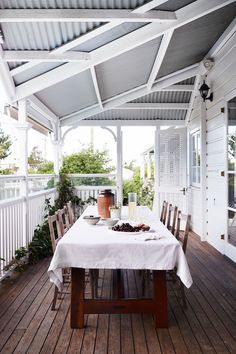 an outdoor dining area with a table and chairs on the wooden floored decking