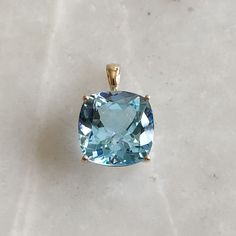 ITEM DESCRIPTION: >>The pendant is made from Solid 14K Yellow Gold. Gemstone used is absolutely natural and ethically sourced. >>Natural Sky Blue Topaz in square cushion shape with prong setting is studded on it with utmost precision. >>This is a minimalist design and is absolutely hassle-free and everyday jewelry. Gem: Sky Blue Topaz Gem size: 15 x 15 mm square cushion Gem weight: 16.00 carats Gold purity: 14K (58.33% approx.) Gold weight: 1.38 grams Gross weight: 4.58 grams The Gold purity is Blue Cushion Cut Jewelry With Gemstone Accents, Cushion Cut Aquamarine Gemstone Jewelry, Blue Aquamarine Cushion Cut Jewelry, Blue Cushion Cut Aquamarine Jewelry, Blue Topaz Gemstones With Prong Setting, Blue Aquamarine Gemstones For Gifts, Blue Aquamarine Gemstones As A Gift, Elegant Large Blue Gemstone, Cloudless Sky