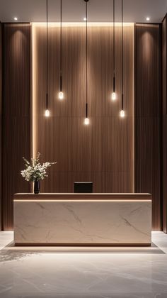 an elegant reception area with marble counter tops and wooden paneling, along with hanging lights