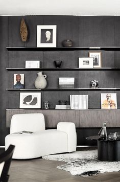 a modern living room with black and white decor on the wall, bookshelves and shelves