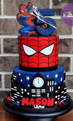 a three tiered cake with spiderman on top and the number five in the middle