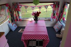 a pink and white polka dot table cloth on a dining room table in front of a window