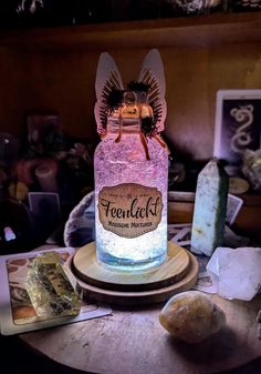 a jar filled with pink liquid sitting on top of a table next to some rocks