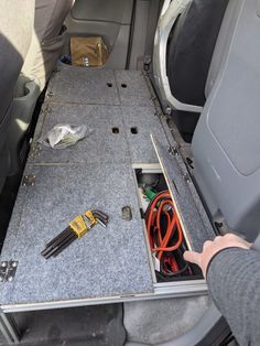 an open trunk in the back of a car with wires and other items inside it