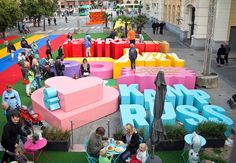 people are standing in the middle of a colorful area with large letters and chairs on it