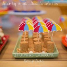 there are many desserts on the table with colorful umbrellas in them, and one is made out of graham crackers