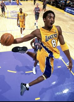 a basketball player is in mid air after dunking the ball while others are on the court behind him