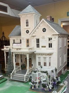 a large white doll house sitting on top of a table