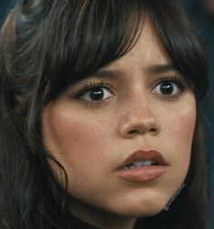 a close up of a woman with long hair and bangs on her head looking at the camera