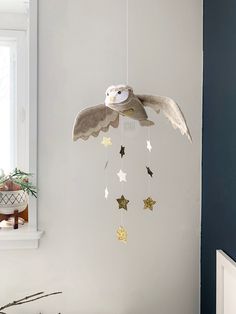 an owl mobile hanging from the ceiling in a child's room with white walls