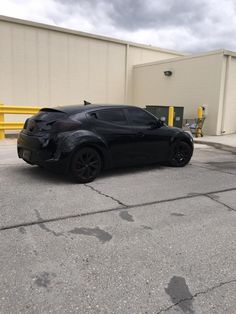 a black sports car parked in front of a building