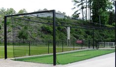 the tennis court is fenced off and ready to be used as a batting cage