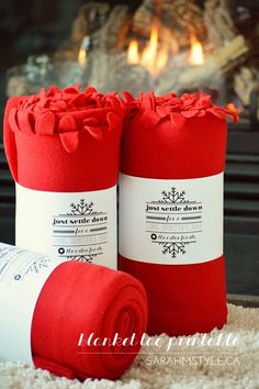 two red blankets sitting on top of a white rug next to a fire place with a fireplace in the background