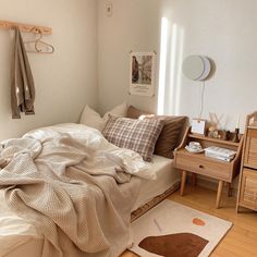 an unmade bed in a bedroom with wooden flooring and white walls on the side