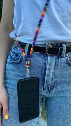 a person wearing a belt with a cell phone in their pocket and a lanyard