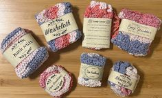 six crocheted washcloths are laid out on a wooden surface with labels