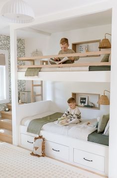 a young boy sitting on top of a bunk bed reading a book in his room