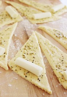 crackers and cheese are arranged on a cutting board with seasoning sprinkles