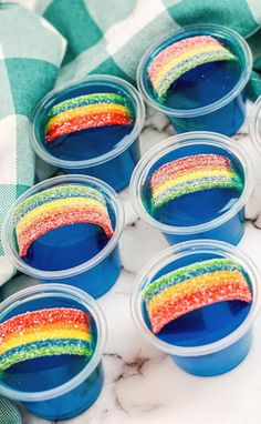 rainbow desserts in plastic cups sitting on a table