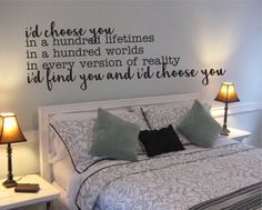 a bedroom with a bed, nightstands and wall decal that says i'd choose you in a hundred words