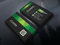 two black and green business cards sitting on top of a table