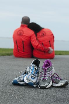 two pairs of running shoes sitting on the ground next to each other with their backs turned