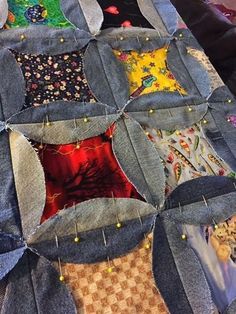 a quilted table top with several different pieces of fabric and buttons on the edge