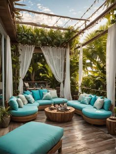 a blue couch sitting on top of a wooden floor next to a lush green forest