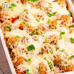 a casserole dish with meatballs and cheese on top, garnished with parsley