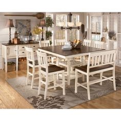 a dining room table and chairs in front of a fireplace