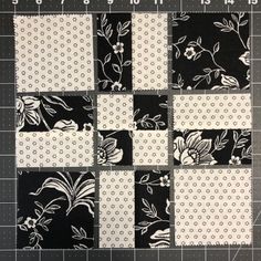 the block is made up of black and white fabric with flowers on it, along with dots