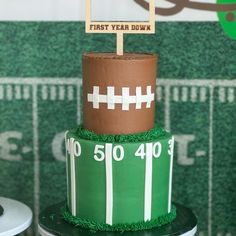 a football themed birthday cake with a first year down sign on top and grass around the edges