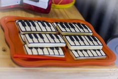 four cookies decorated like piano keys on a tray