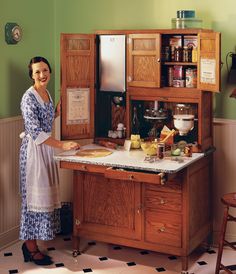 a woman standing in front of a kitchen counter with lots of food on top of it