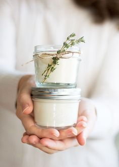 a person holding a jar with some plants in it