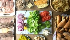 a table topped with lots of different types of food next to breads and vegetables