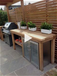 an outdoor grill with potted plants on top